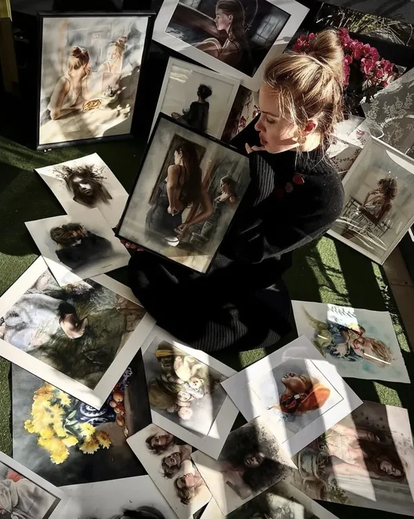Nataliia zwischen ausgelegten Porträt-Drucken, von oben fotografiert